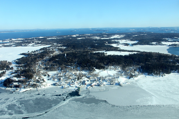 North Haven buried in snow and locked in ice.  The small area of open water near the ferry pen was created by the ferry maneuvering at the landing.
